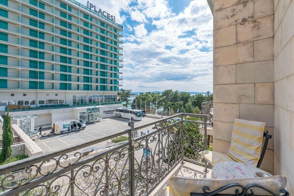 A hotel with a balcony, a parking area, and a building with 'PLACES' signage.