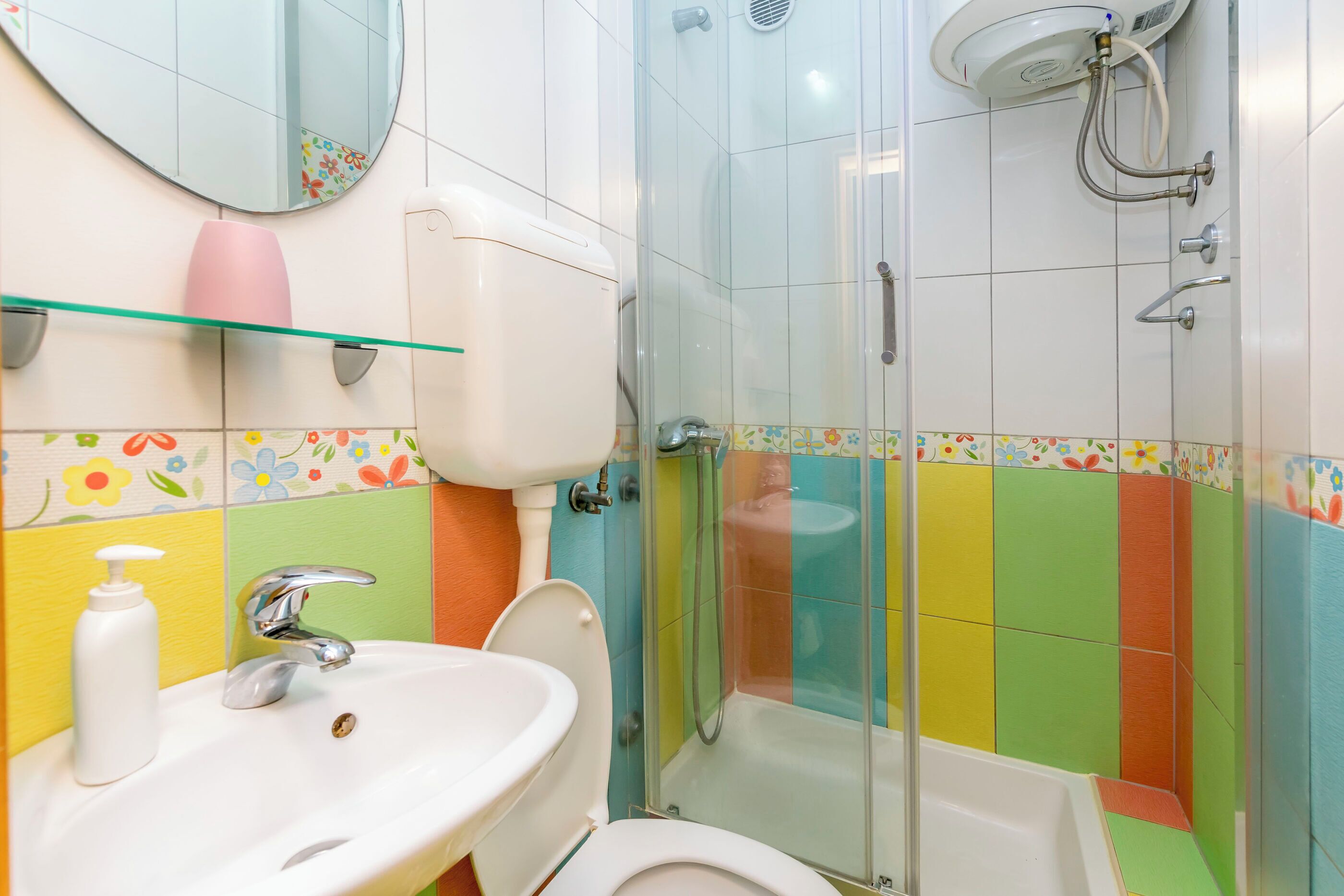 A bathroom with a toilet, sink, and shower.