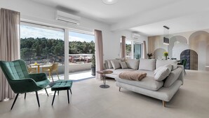 A modern living room with a sofa, armchair, and round coffee table. - Apartment Luxury Wellness (Makarska)