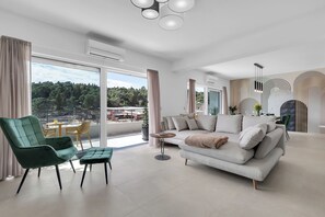 Ein modernes Wohnzimmer mit einer Couch, einem Sessel und einem runden Couchtisch.