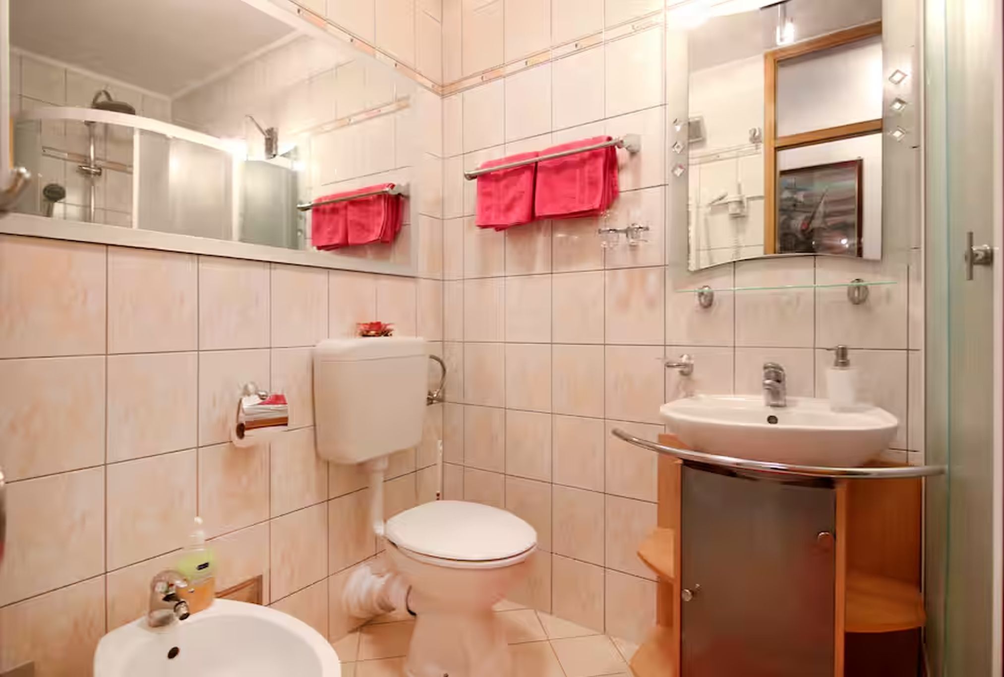 Un baño con inodoro, lavamanos y espejo.
