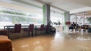 A spacious lobby with a long table and several chairs, large windows, and a modern interior design. - Spacious DBL Suite Near Mall Panakkukang W/ WiFi (Makassar)