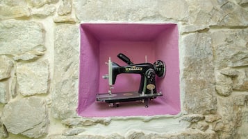 Una máquina de coser antigua en un nicho de pared de piedra.