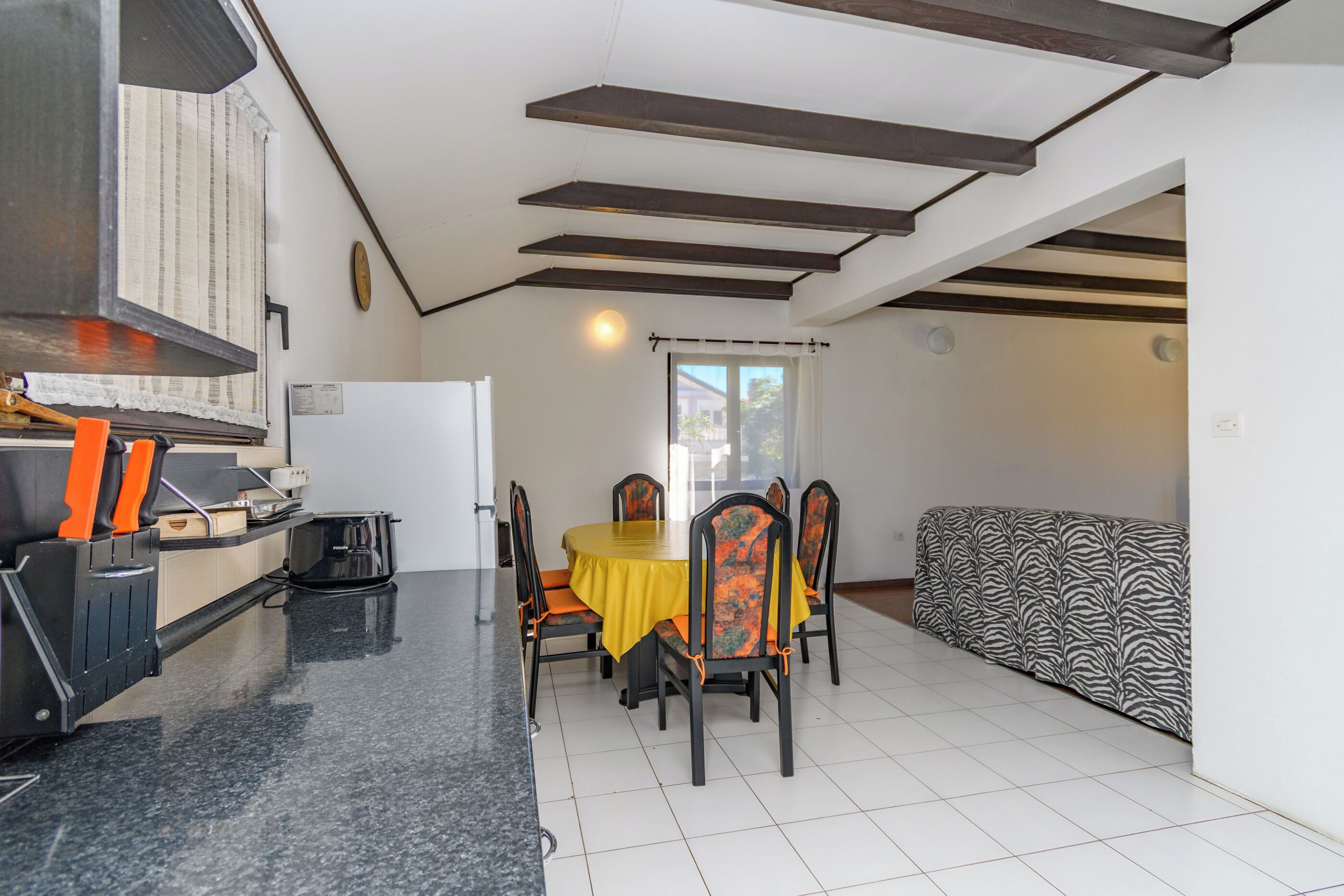 A compact living space with a kitchen, dining area, and a sofa.