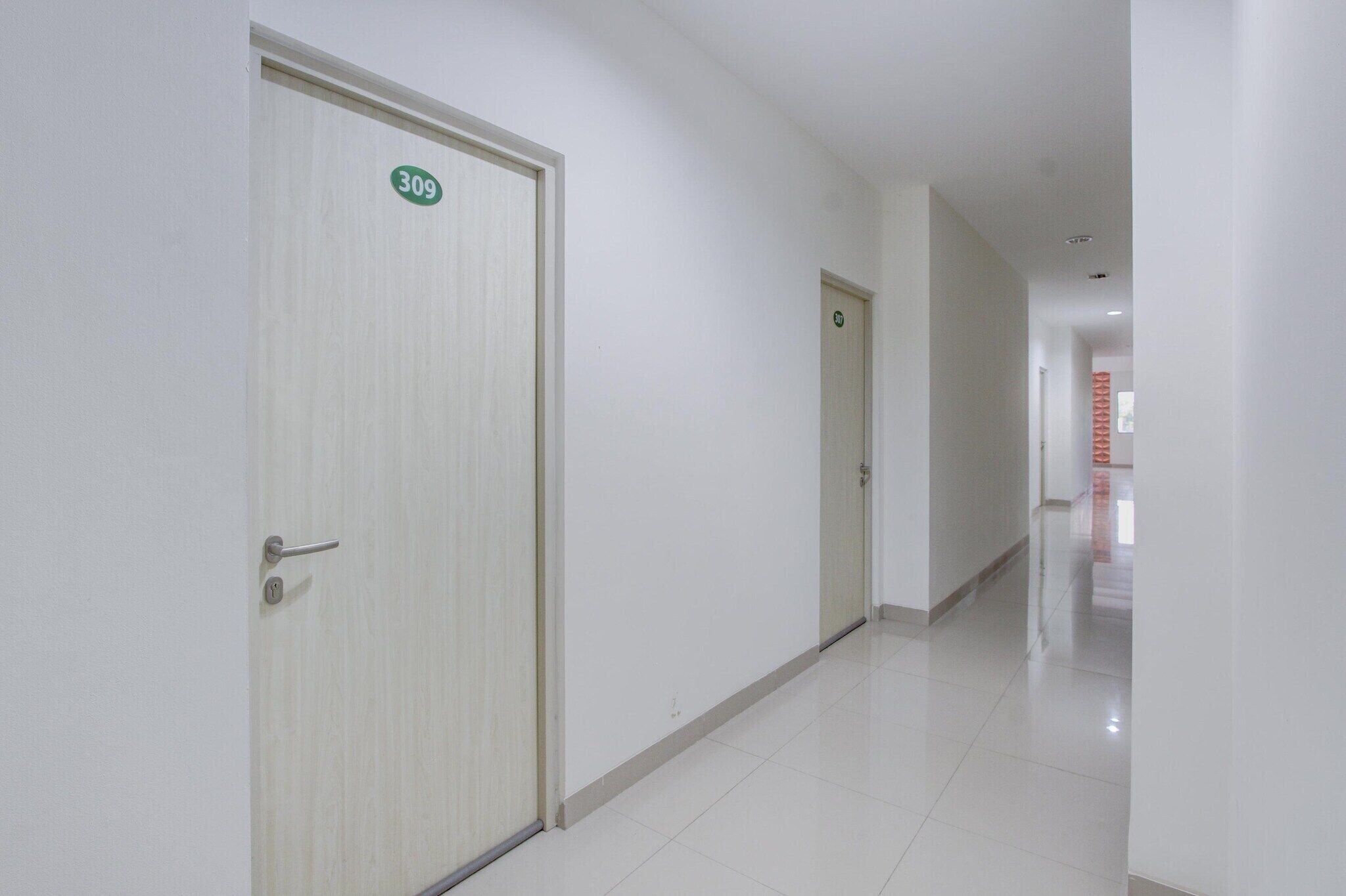 Un pasillo con puertas numeradas 309 y 310, que dan acceso a habitaciones.