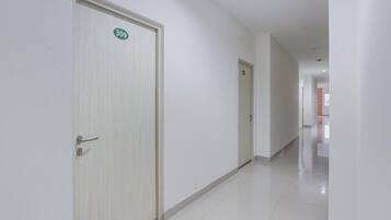 Un pasillo con puertas numeradas 309 y 310, que dan acceso a habitaciones.