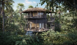 A multi-level wooden structure with balconies, surrounded by dense tropical foliage.