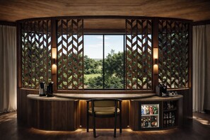 A bar area with a wooden interior, a view of greenery outside, and a seating arrangement.