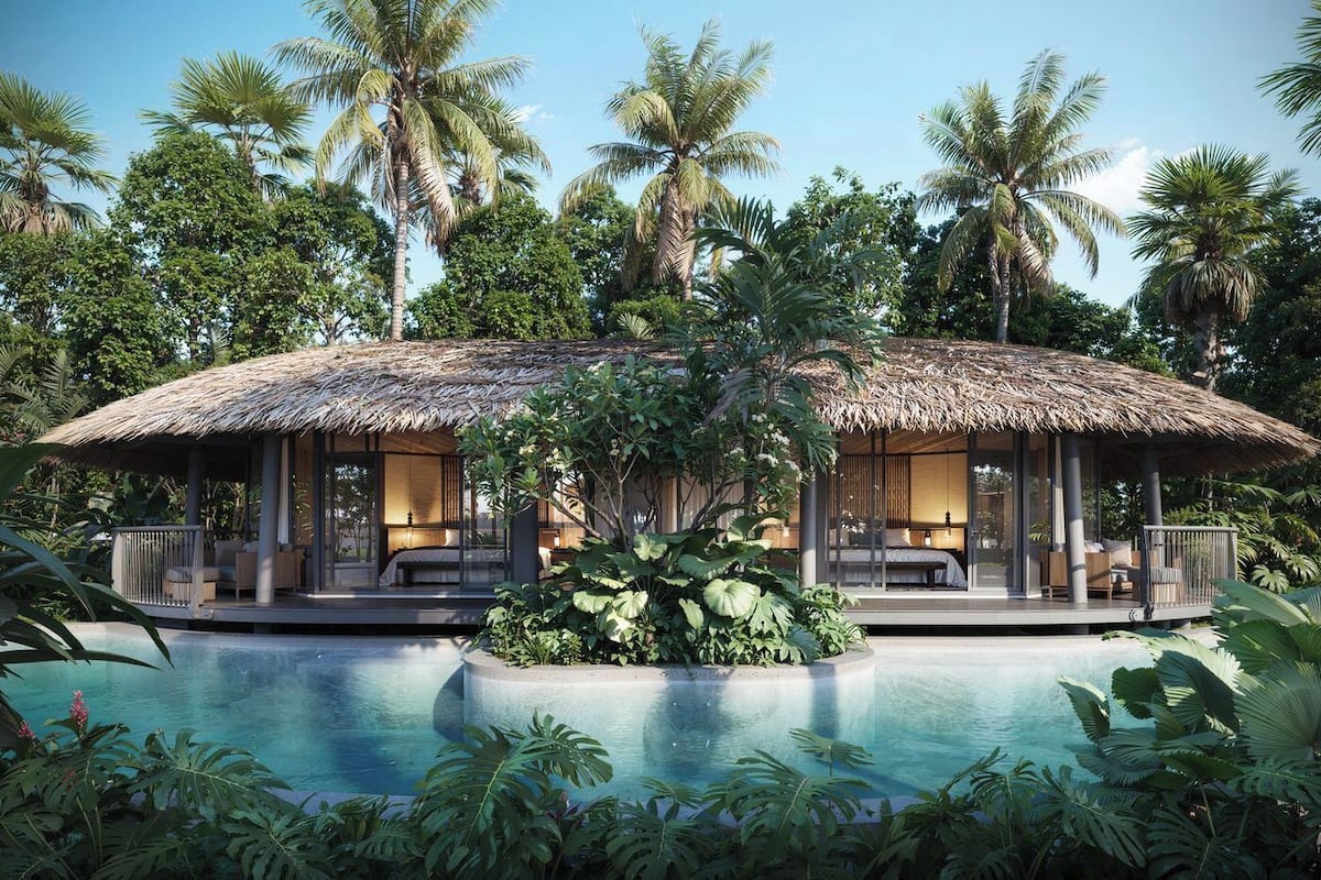 A resort with a pool, thatched-roof structures, and lush tropical vegetation.