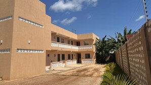 A two-story building with a flat roof and a balcony on the second floor. - Cozy studio apartment in adorable Diani with AC 4mnts to the Beach (Ukunda)