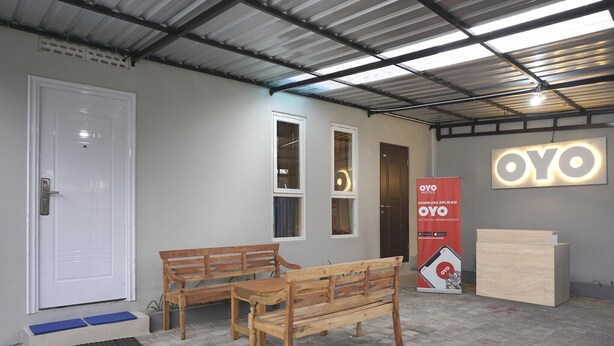 Una zona de recepción con un banco de madera, un mostrador y una puerta.