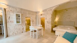 A room with a bed, a table, and a chair. - Suite Ninfea – Historic Home in the Heart of Ostuni (Ostuni)