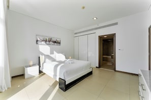 A modern bedroom with a bed, bedside tables, a painting, and a wardrobe. - Chic 1BR APT in DIFC I 7-Min Drive to Burj Khalifa (Dubai)