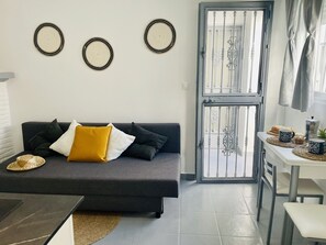 Una sala de estar con sofá, una mesa de centro y un comedor con mesa y sillas.