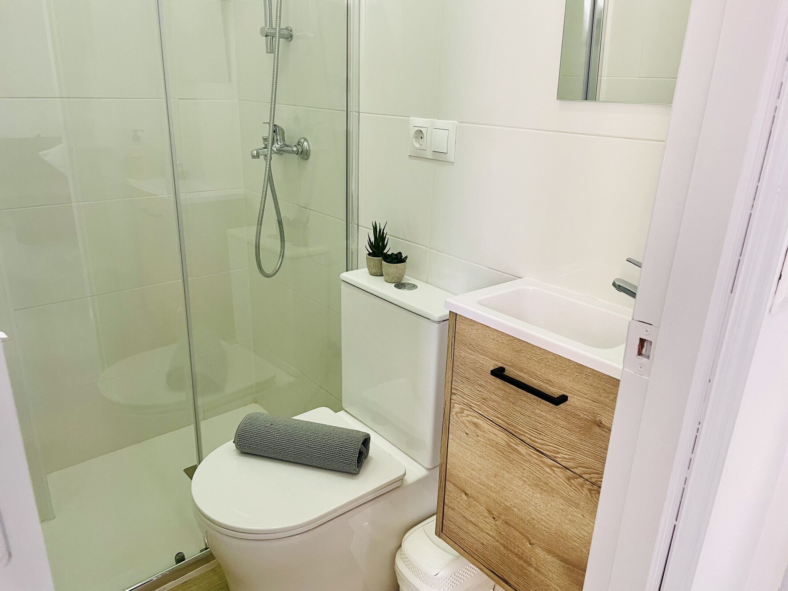 A bathroom with a shower, toilet, and sink.