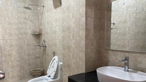 A bathroom with a toilet, bidet, and sink.