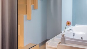 A modern bathroom with a white bathtub, a wooden staircase, and a glass shower enclosure. - Moderno Hotel Roma (Rome)