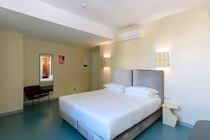 A hotel room with a large bed, a chair, a desk, and a mirror. - Moderno Hotel Roma (Rome)