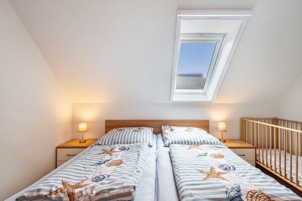 Ein Schlafzimmer mit zwei Betten, einem Oberlicht und Nachttischlampen.