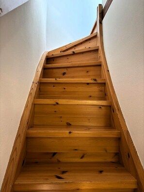 Eine Holztreppe mit Handlauf, die nach oben führt.