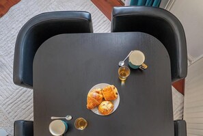 A table with pastries and cups, surrounded by black chairs. - Fécomsi Escale - A cocoon in Le Mans - L'Instant Clef (Le Mans)
