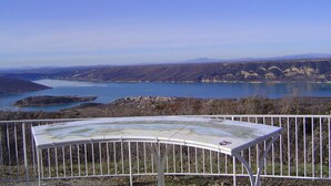 A scenic overlook with a map table, a railing, and a view of a lake and distant hills. - Le Buis Authentic village house 4 people (Aiguines)
