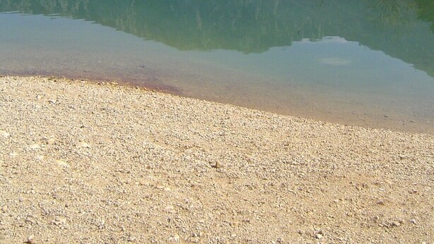 A natural landscape with a lake, pebbly shore, and mountains in the background. - Le Buis Authentic village house 4 people (Aiguines)