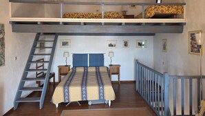 A loft-style bedroom with a bunk bed, a desk, a chair, a ladder, and a railing. - Le Buis Authentic village house 4 people (Aiguines)
