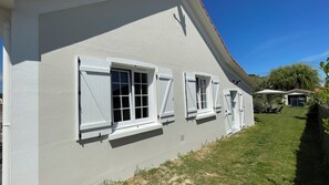 A house with white exterior walls, multiple windows with shutters, a visible garage, and a well-maintained lawn. - House just a stone's throw from the sea. 350 meters from the beach. (La Plaine-sur-Mer)