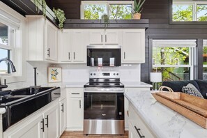 Horno, placa de cocina, utensilios de cocina y mesa de comedor