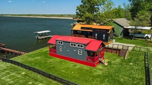 A lakeside property with a house, dock, and a small boat. - Lakefront Retreat Paradise (Pittsburg)