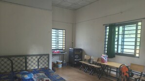Une pièce comprenant un lit, un bureau, une chaise, une table et une fenêtre.