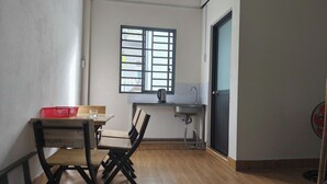 Une pièce comprenant une table à manger, des chaises, une fenêtre, un évier et un ventilateur.