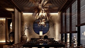 A modern dining area with a central round table, surrounded by chairs, and a ceiling with a unique design. - Q Hotel Dhaka (Dhaka)