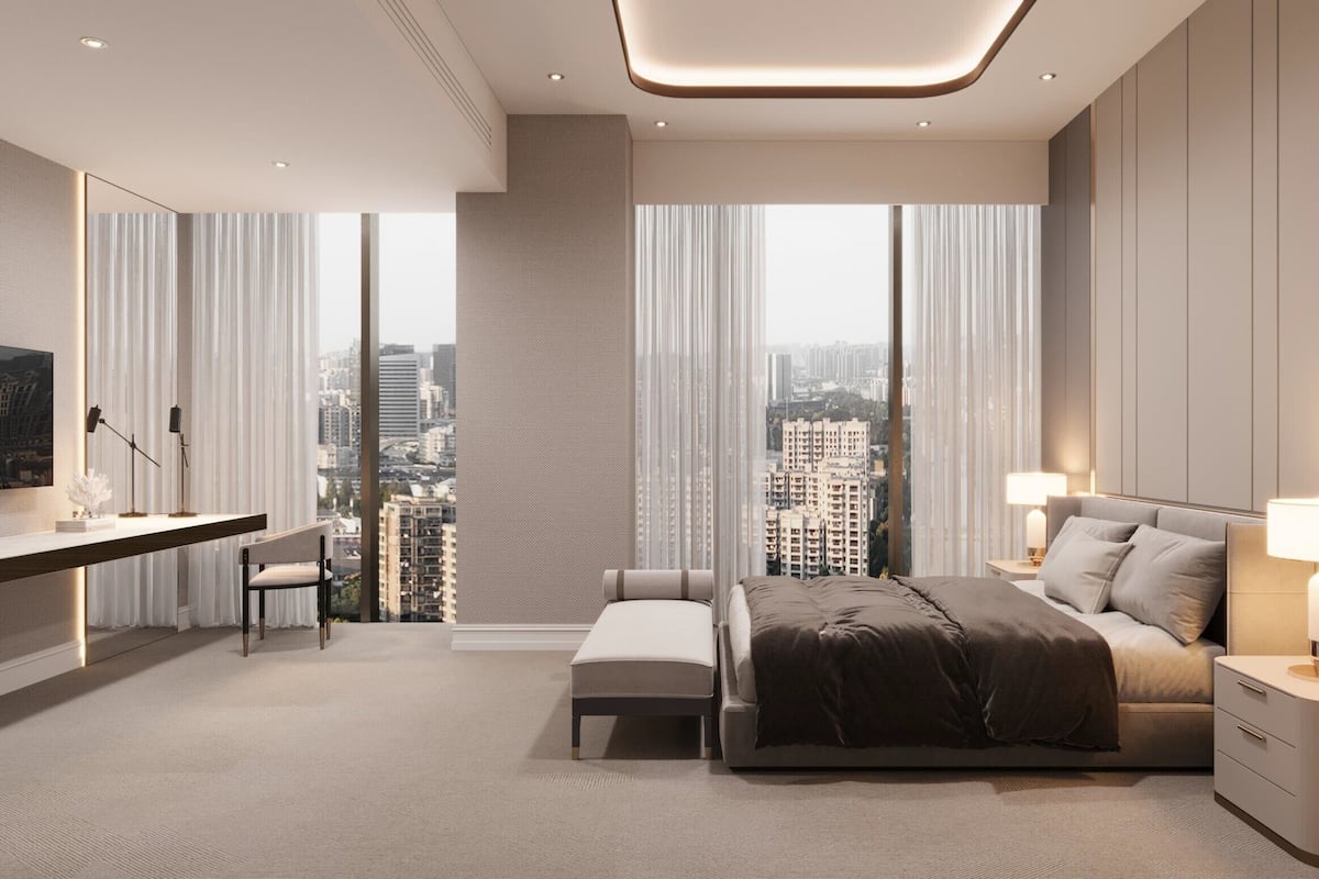 A modern hotel room with a large bed, a desk, and a view of the cityscape.