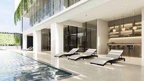A modern indoor pool area with lounge chairs, a reception desk, and a glass-enclosed space. - Q Hotel Dhaka (Dhaka)
