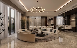 A modern living room with a circular sofa, a coffee table, and a chandelier.