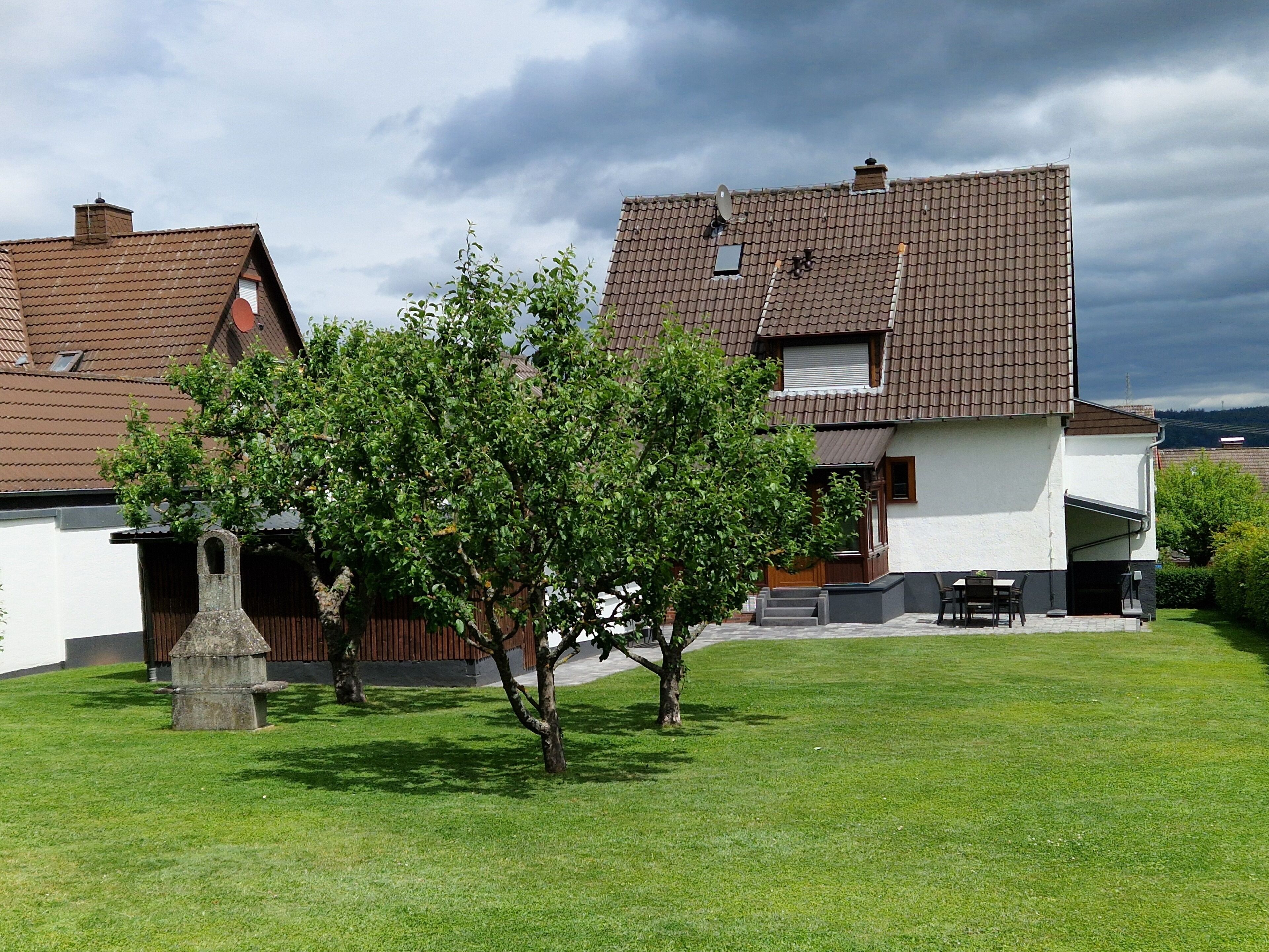 A residential area with houses, a lawn, and a tree.