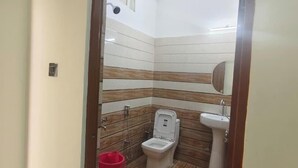 Un baño pequeño con inodoro, lavamanos y espejo.