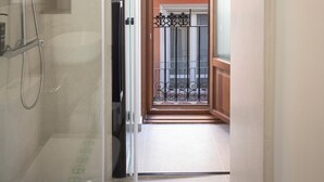 Un baño con cabina de ducha de vidrio, una toalla y un inodoro.