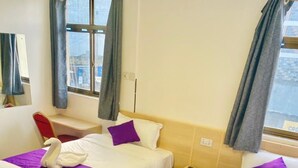 A hotel room with two beds, each with a purple blanket and a white swan decoration. - LIAZONS HOTEL NAKURU (Nakuru)