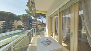 A balcony with a table, chairs, and a view of the surrounding buildings. - Prime Lignano stay close to the sand (Lignano Sabbiadoro)