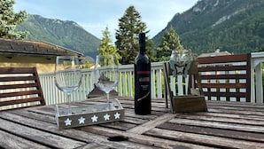 A wooden deck with a bottle of wine, two glasses, and a star-shaped tray.