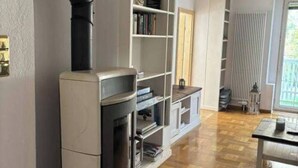 A modern living room with a built-in fireplace, a bookshelf, and a dining area.