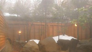 A hot spring bath with rocks and a wooden fence. - Hirayu Onsen KKR Hirayu Takaraso (Takayama)
