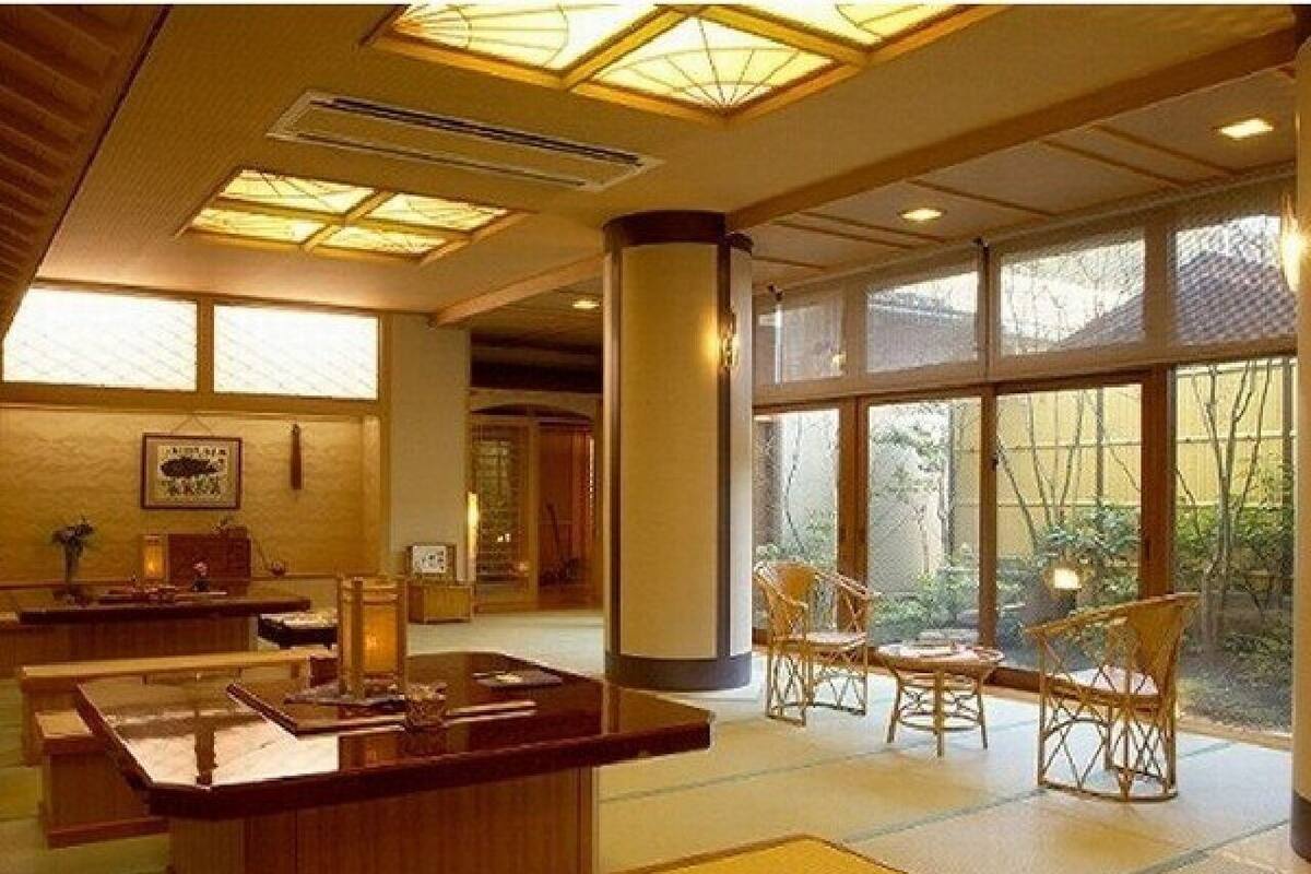 A hotel lobby with a reception desk, seating area, large windows, and a central column.