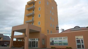 Un edificio a più piani con facciata piatta, ingresso coperto e vetrina con insegna.