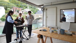 An outdoor dining area with a grill, table, and chairs.
