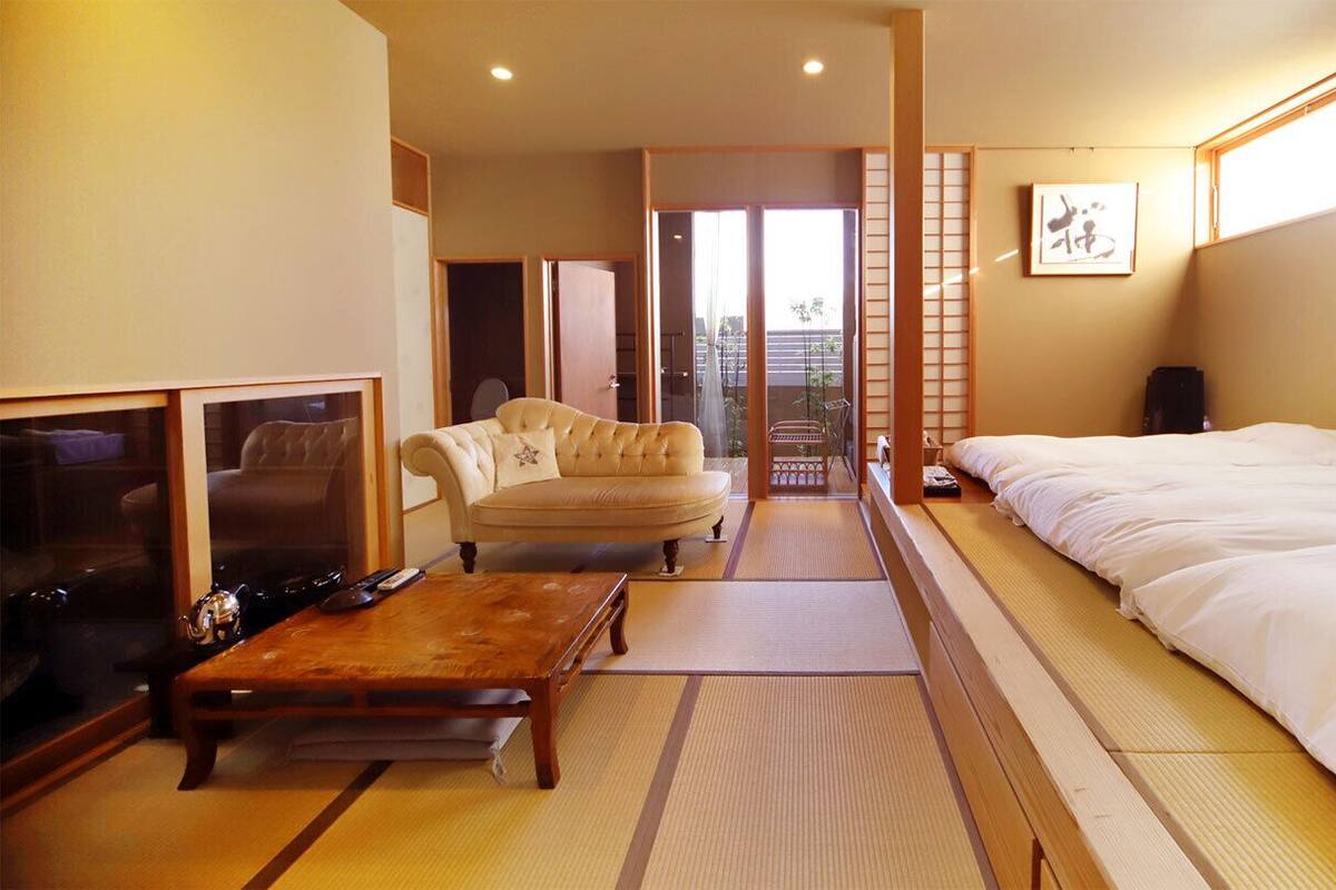 A hotel room with a bed, a sofa, a coffee table, and a television.