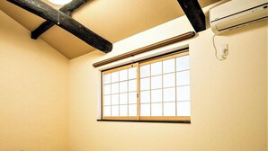 A room with tatami flooring, a shoji screen window, and a small black object on the floor. - Kyorana Kyogetsutei (Kyoto)